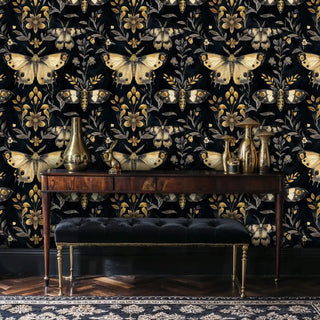 Detailed view of black-gold moth wallpaper, shown with a wood console