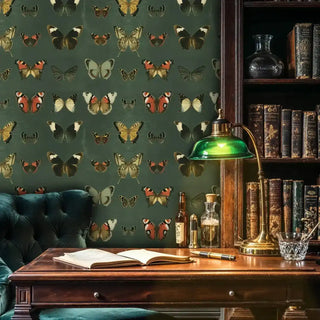 Detailed view of butterfly wallpaper, deep green and ochre, vintage, with green desk lamp
