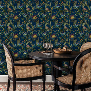 Detailed view of hummingbird wallpaper in navy and green, shown with dining table and wine glasses