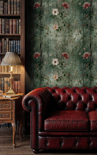 Distressed botanical wallpaper with burgundy flowers on weathered green background, displayed in traditional library setting