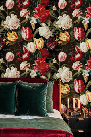 Dutch floral wallpaper with red tulips and cream peonies on dark background, in luxurious bedroom with green velvet pillows
