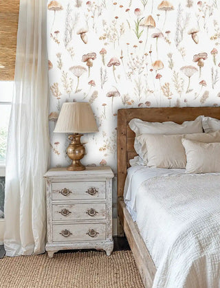 Earthy mushroom and grass wallpaper in soft beige tones, displayed in cozy bedroom with brass lamp