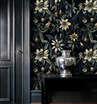 Elegant dark floral clematis wallpaper with cream blooms, shown in refined interior with silver decorative urn