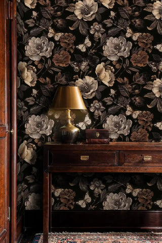 Elegant floral wallpaper with butterflies and large blooms, styled in home office with brass lamp