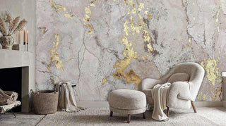 Elegant gold and grey concrete wall mural shown in a cozy reading nook with a curved boucle armchair and minimalist fireplace.