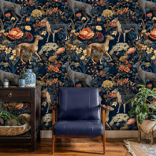 Enchanted forest wallpaper featuring deer, rabbits and florals in navy, gold tones, styled in modern living room with navy leather chair