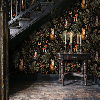 Enchanted forest wallpaper featuring foxes and rabbits, displayed under staircase with antique table