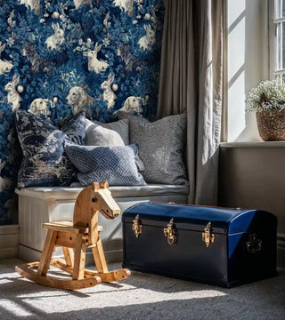 Enchanted forest wallpaper featuring woodland creatures, displayed in reading nook with window seat and pillows