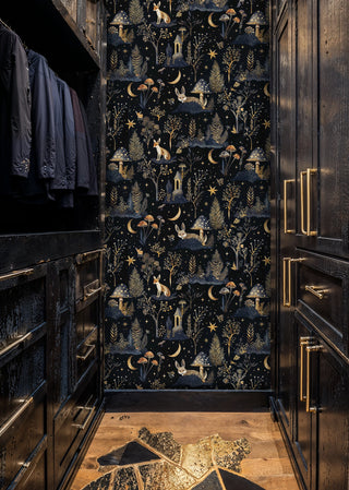 Enchanted forest wallpaper with foxes, mushrooms, and golden ferns on navy background, in dark wardrobe