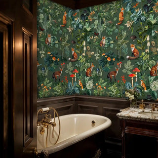 Enchanted forest wallpaper with orange foxes and red mushrooms on a dark green background, in a moody bathroom with a classic tub.