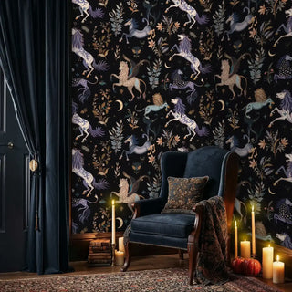 Enchanted forest wallpaper with winged lions and botanical elements, shown in cozy reading nook with navy wingback chair