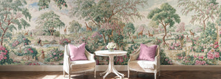 Enchanted garden mural with pink roses and giraffes behind two cream armchairs with pink cushions