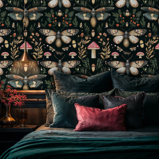 Enchanted moth and mushroom wallpaper on dark background, in a moody bedroom with velvet pillows and pendant lamp