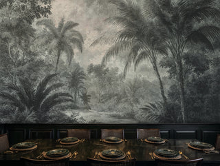Engraved jungle wall mural with misty tropical trees, in an elegant dining room with gold place settings