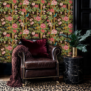 Exotic bird and peony wallpaper on chocolate background, shown in a sophisticated living room with leather armchair