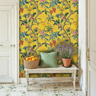 Exotic fruit tree wallpaper with golden citrus and coral flowers on yellow backdrop, in rustic entryway with wicker basket