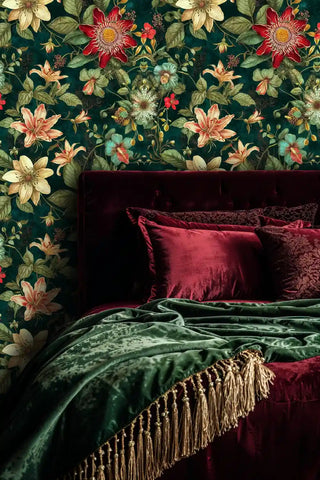 Exotic passion flower wallpaper in emerald and coral, styled in opulent bedroom with burgundy velvet headboard