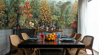 Exotic tropical wallpaper with palm fronds and colorful blooms in modern dining room with brass bar cart