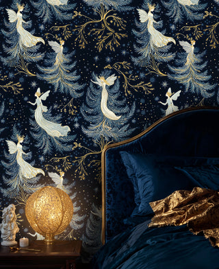Fairy wallpaper with white winged figures and gold branches in navy, shown by a velvet bed and glowing orb lamp