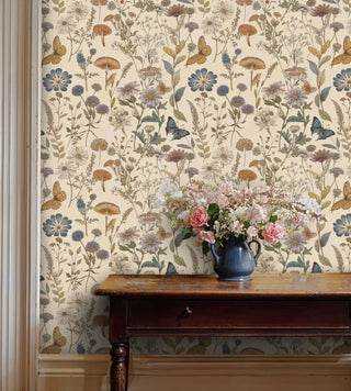 Floral botanical wallpaper with mushrooms and butterflies in muted colors, shown in cozy room with antique chest