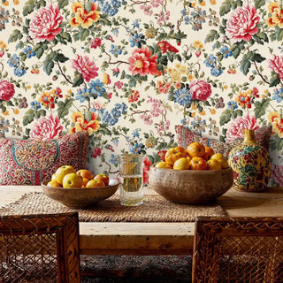 Floral cottage wallpaper with coral and blue blooms displayed in dining room with woven chairs