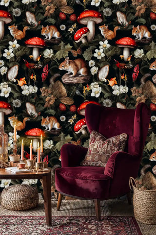 Forest animals wallpaper featuring red toadstools and squirrels, styled in cozy reading nook with burgundy chair