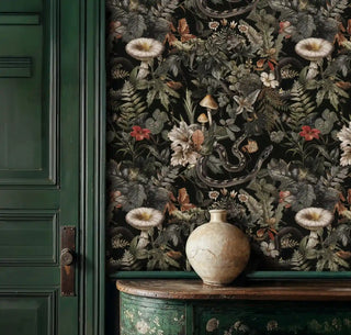 Forest botanical wallpaper with serpents and mushrooms displayed beside vintage green cabinet with ceramic vase
