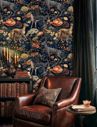 Forest tapestry wallpaper with deer and botanical elements in navy and gold, shown in formal dining room with cane chairs