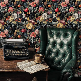 Fruit and floral wallpaper with dramatic dark background in vintage study with antique typewriter and leather chair