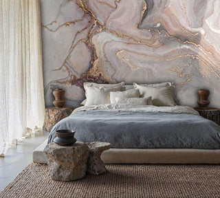 Geode pattern wallpaper in grey and gold tones shown in minimalist bedroom with stone sculptural nightstands
