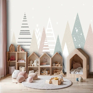 Geometric mountain wallpaper with triangular peaks in sage and pink, shown in playful kids room with wooden toy houses
