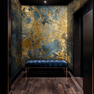 Gilded abstract Wall Mural with gold on deep blue, shown in a hallway with navy tufted bench and ceiling spotlight