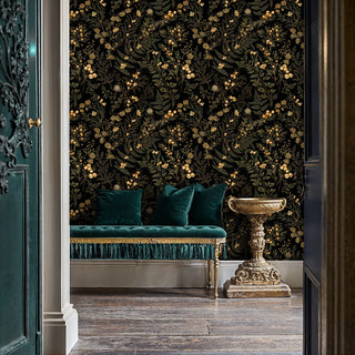 Gold and green botanical wallpaper on black, shown in an entryway with teal tasseled daybed and stone urn