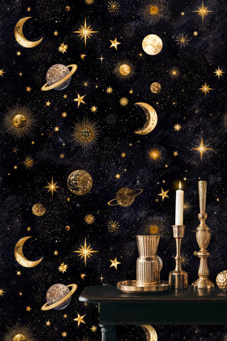 Golden celestial wallpaper featuring cosmic motifs shown in elegant room with brass candlesticks and decor