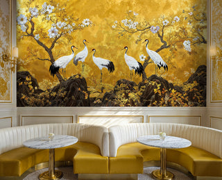 Golden crane wall mural with white birds and cherry blossoms on gold, in a chic cafe with marble tables