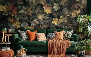 Golden leaf pattern wallpaper in cozy living room with green sofa and orange throw pillows