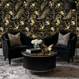 Golden meadow wallpaper featuring delicate florals and ferns, displayed in luxury living room with velvet chairs