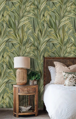 Golden palm leaves wallpaper with sage green background in bedroom with wicker nightstand