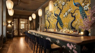 Golden peacock wall mural with flowering branches in elegant hotel bar with lanterns