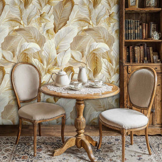 Golden tropical leaf wallpaper with honey and cream tones, displayed in traditional dining room with antique bookshelf
