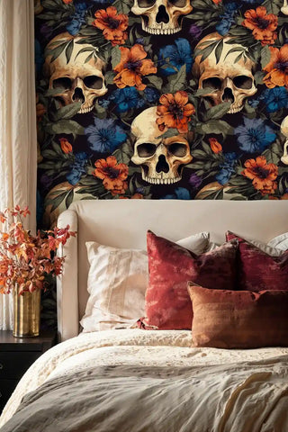 Gothic botanical wallpaper with skull motifs displayed in sophisticated bedroom with red velvet pillows