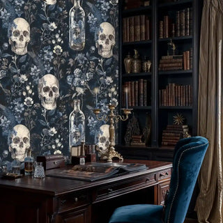 Gothic floral wallpaper with skulls and glass bottles on navy, shown in elegant study with leather-bound books