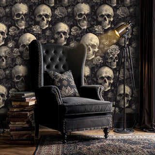 Gothic pattern wallpaper with skulls and florals shown in dark study with leather wingback chair
