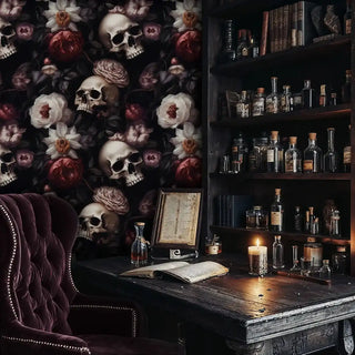 Gothic skull and floral wallpaper in a dark academia study with a wood desk, open book, and lit candle.