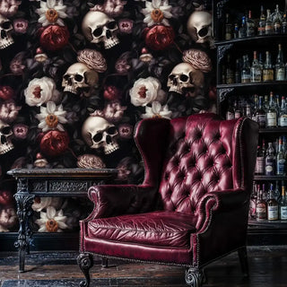 Gothic skull and floral wallpaper in a vintage room with a red leather wingback chair and a fully stocked bar shelf.
