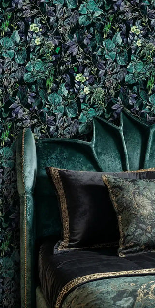 Green and purple botanical wallpaper with delicate cream flowers, styled in sophisticated sitting area with emerald velvet armchair