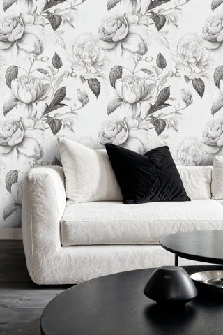 Grey botanical wallpaper with large roses, featured in sophisticated living room with beige sofa