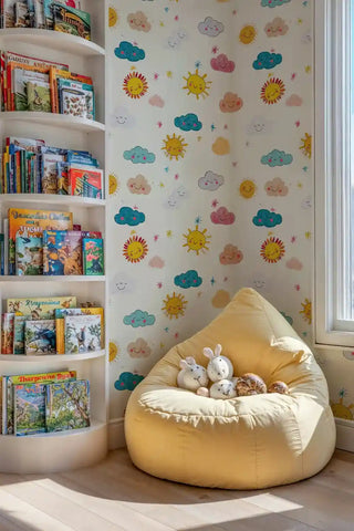 Happy sun and cloud kids wallpaper with cheerful faces, displayed in reading nook with yellow bean bag chair
