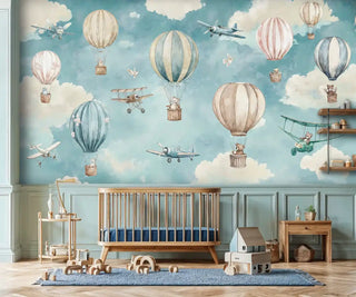 Hot air balloon wall mural with vintage airplanes and fluffy clouds displayed in a Scandinavian nursery with wooden crib and natural toys