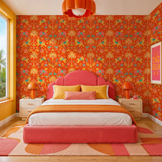 Indian folk art wallpaper with tigers and florals on orange, in a colorful bedroom with pink upholstered bed